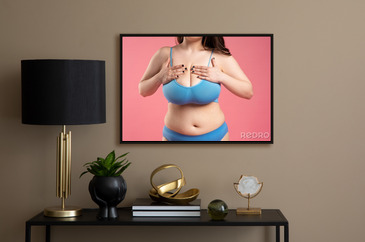 Woman checking her very large breasts for cancer on pink