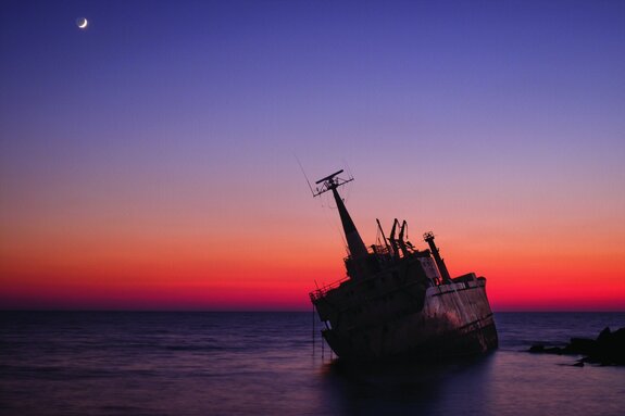 Schiffswrack auf dem meer bei sonnenuntergang