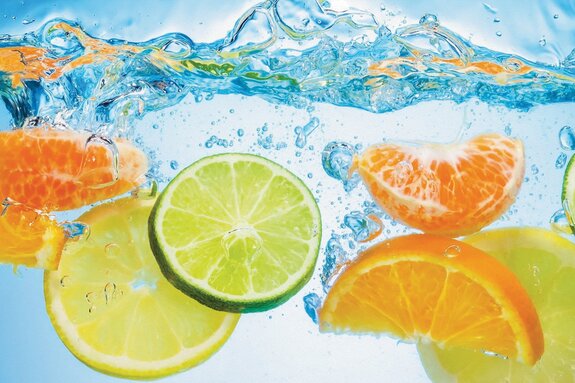 Zitronen und orangen, die ins wasser fallen