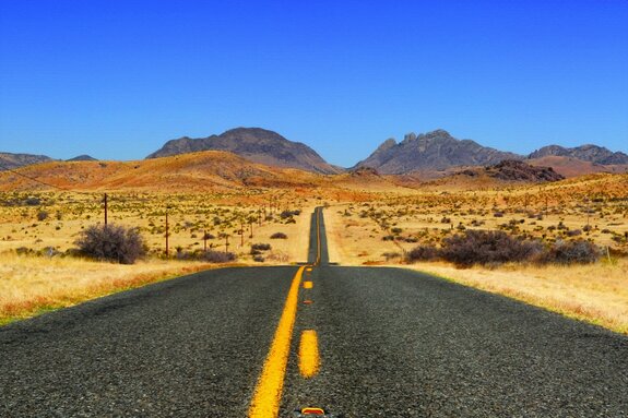 Betonstraße, die durch die mitte der wüste führt