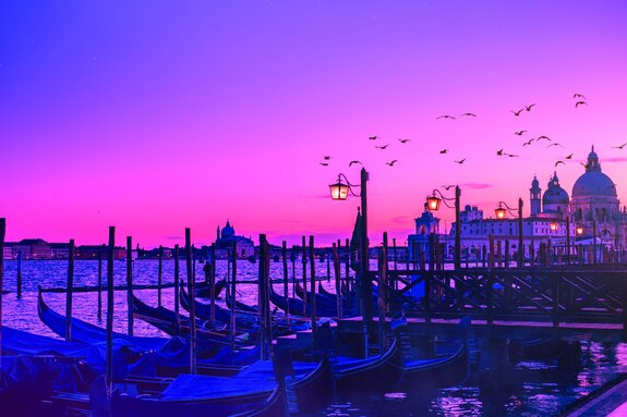 Venezianischer sonnenuntergang mit gondeln und kathedrale im hintergrund