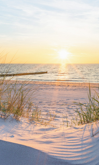 Malerischer blick auf den sonnenuntergang über dem meer von einem sandstrand