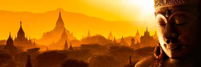 Buddha mit tempeln im hintergrund bei sonnenuntergang