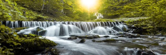 Ein breiter wasserfall mit felsen und steinen