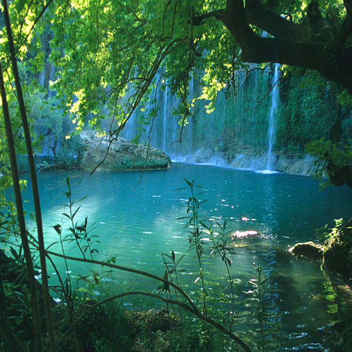 Ein tropischer wasserfall, der in türkisfarbenes wasser stürzt