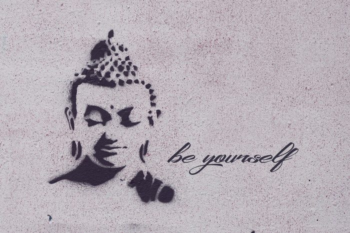 Graffiti eines buddha-gesichts mit dem text "sei du selbst"