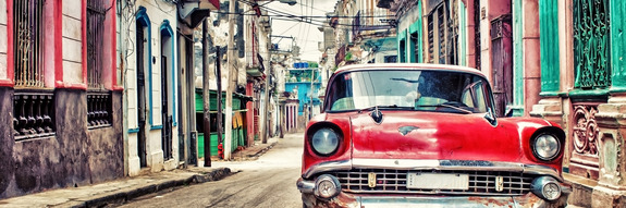 Ein roter oldtimer parkt in der altstadt von havanna.
