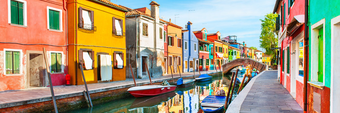 Die uferpromenade mit booten und farbenfrohen gebäuden in venedig