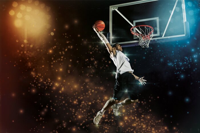 Ein basketballspieler schlägt den ball im licht