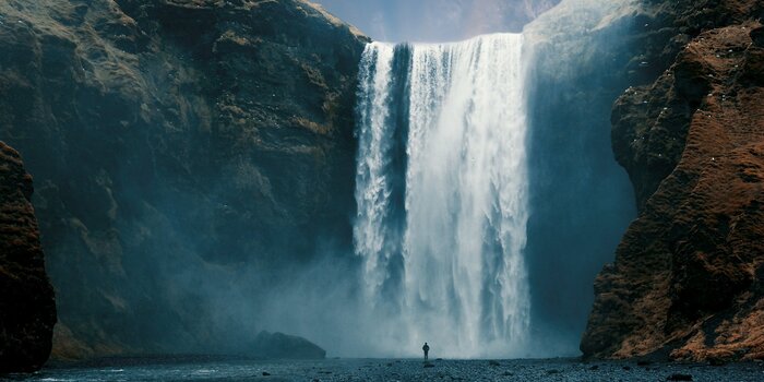 Ein großer wasserfall, der von den felsen herabstürzt.
