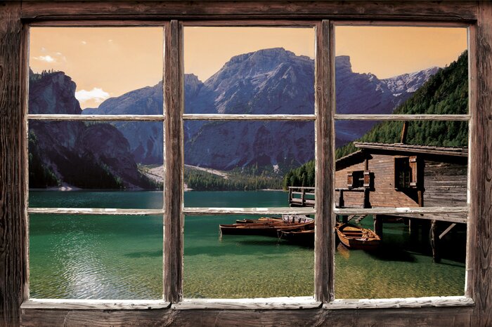 Holzsteg und boote vor der kulisse der berge