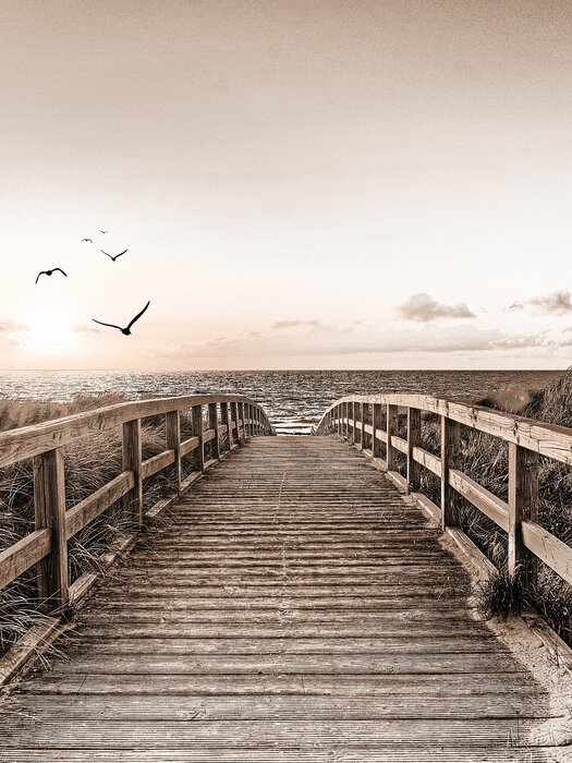 Holzbrücke mit blick auf den sonnenuntergang über dem meer