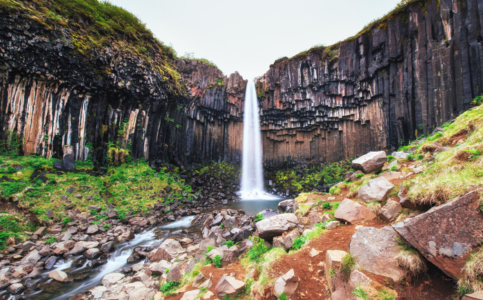 Fototapete Landschaft mit Wasserfall inmitten der Felse