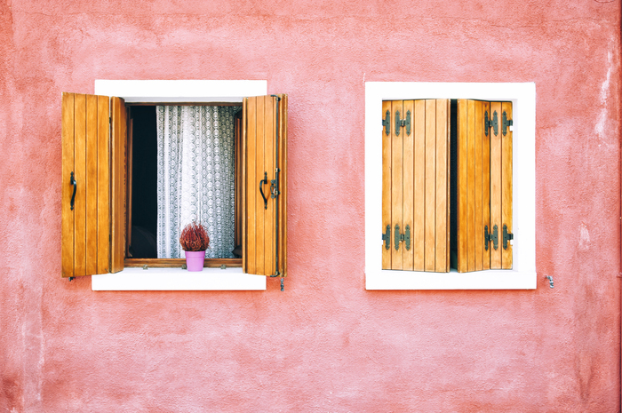 Fototapete Schöne bunte Hausfassade auf Burano-Insel, Norditalien. Rote zwei Fenster mit hölzernen Fensterläden
