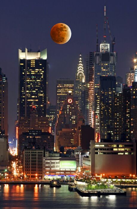 Fototapete Orangefarbener Mond über Wolkenkratzern