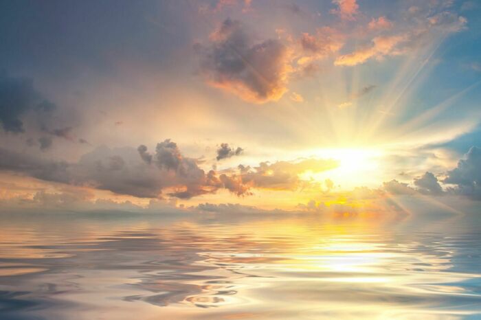 Fototapete Schöne Sonnenuntergang über Meer mit Reflexion im Wasser, majestätische Wolken am Himmel