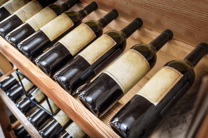 Fototapete Weinflaschen auf Holzregal platziert