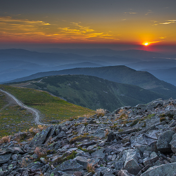 Le soleil couchant derrière les montagnes