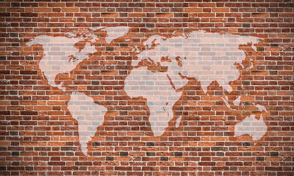 Une carte du monde sur un fond de briques rouges