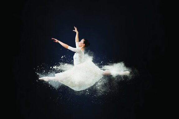 Femme en robe blanche en grand écart