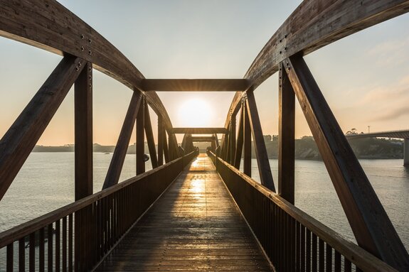 Pont en bois au-dessus de la rivière sous les rayons du soleil