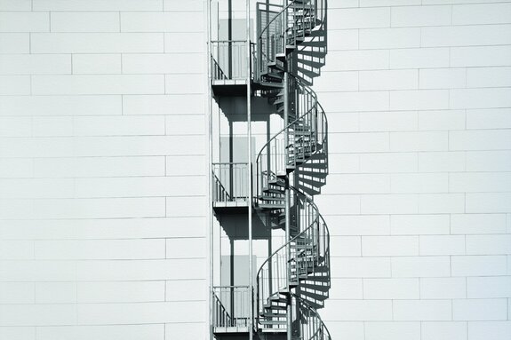 Escalier en colimaçon sur un mur en briques blanches