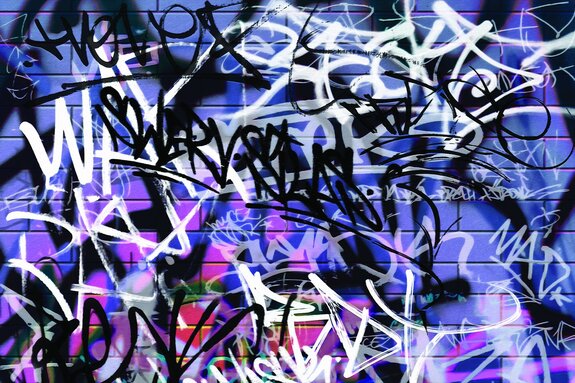 Inscriptions artistiques sur un mur de briques violettes