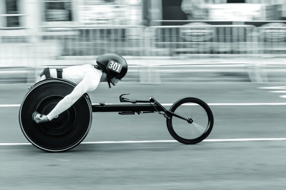 Coureur en fauteuil roulant de course à pleine vitesse