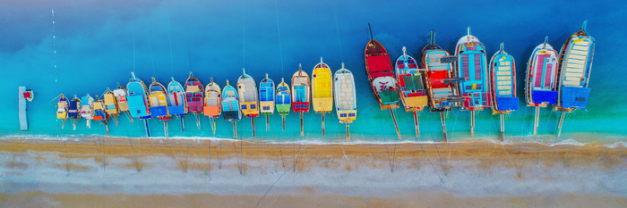 Une rangée de bateaux sur la plage, vue du ciel