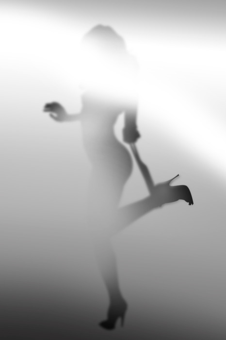 La silhouette illuminée d'une femme sur un fond brumeux