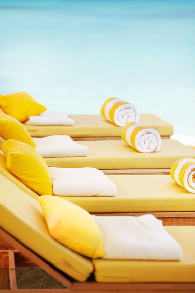 Des chaises longues jaunes sur la plage donnant sur la mer