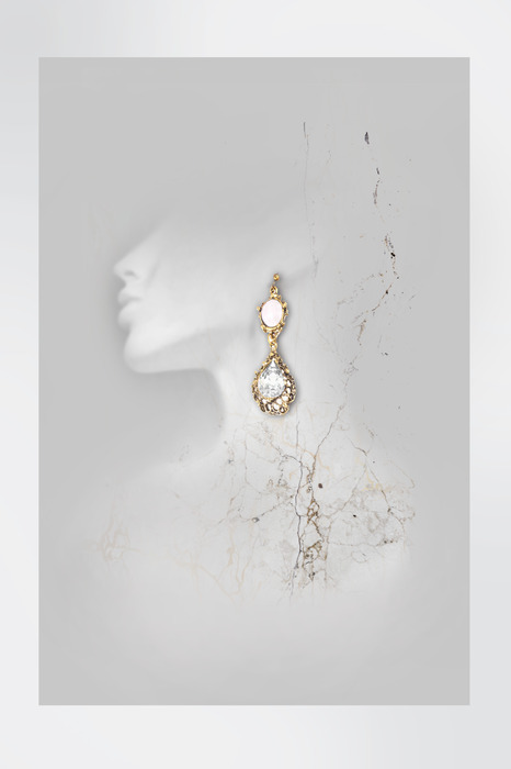 Boucles d'oreilles en or sur la silhouette blanche d'une femme