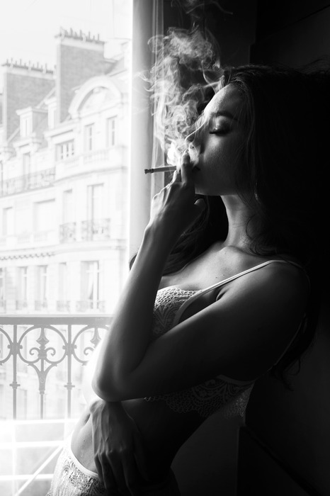 Photo en noir et blanc d'une femme avec une cigarette