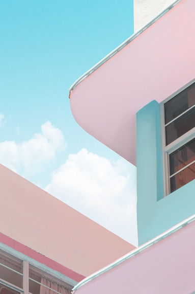 La façade de la maison, aux nuances de rose et de bleu, se détachant sur le ciel.