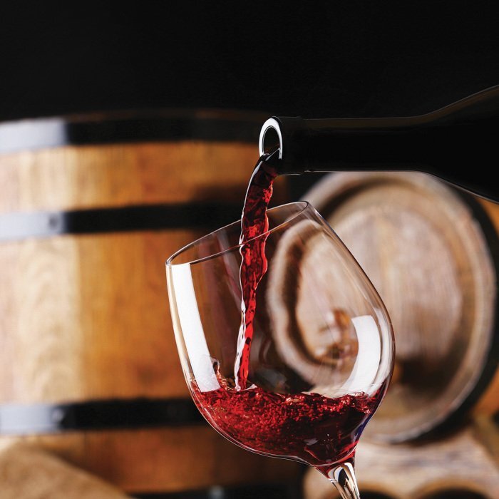 Du vin dans un verre avec un fond rustique de tonneaux