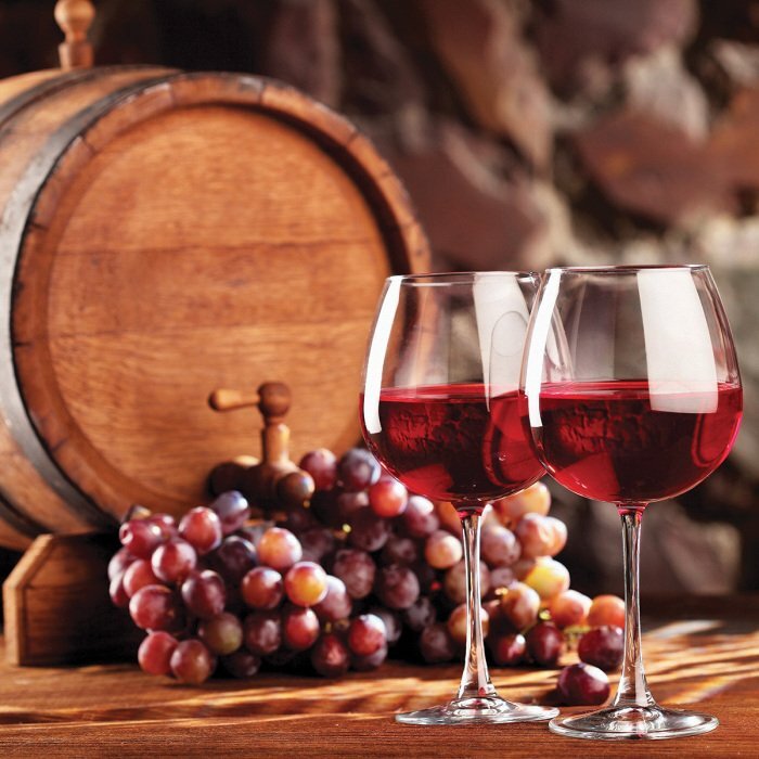 Des verres de vin sur fond de raisins et d'un tonneau en bois