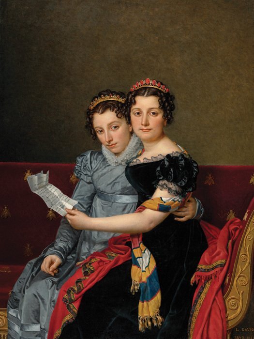 Des femmes avec une lettre sur un canapé rouge