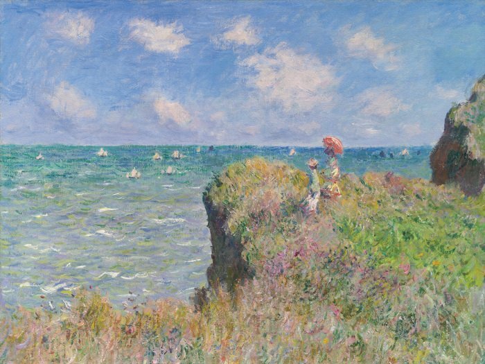 Une femme avec un parapluie sur une falaise fleurie