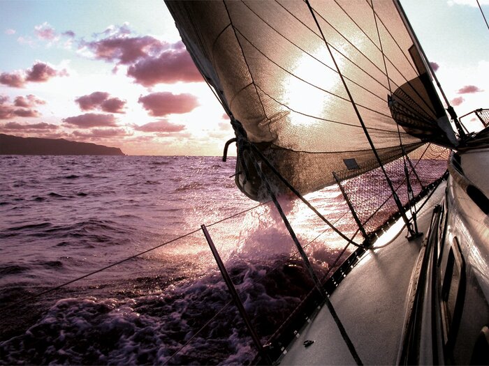 Un bateau à voile dans la lumière du soleil couchant
