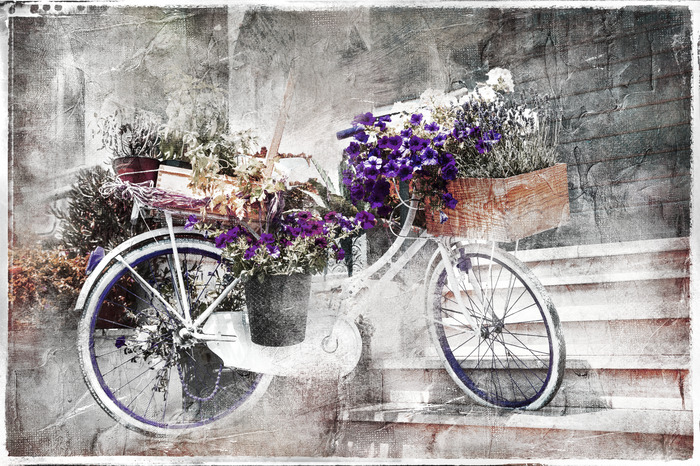 Un vélo classique orné d'un bouquet de fleurs violettes