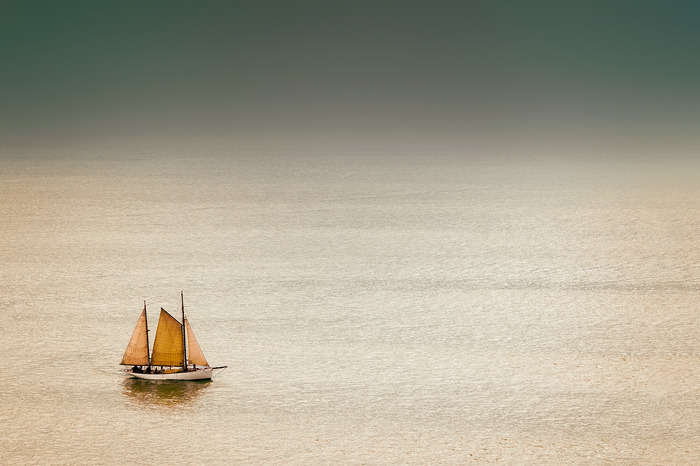 Un voilier solitaire à l'horizon de la mer
