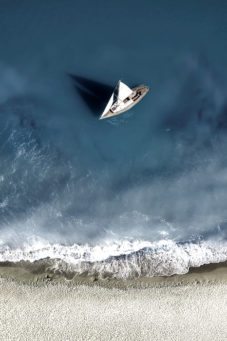 Un bateau blanc à la frontière du sable et des vagues