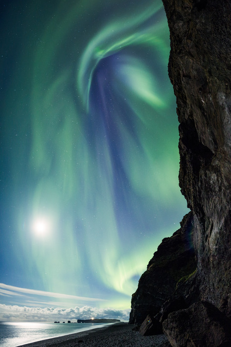Aurore boréale verte au-dessus de la falaise nocturne