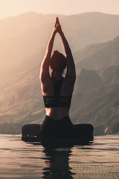 Femme méditant au bord d'un bassin paysager