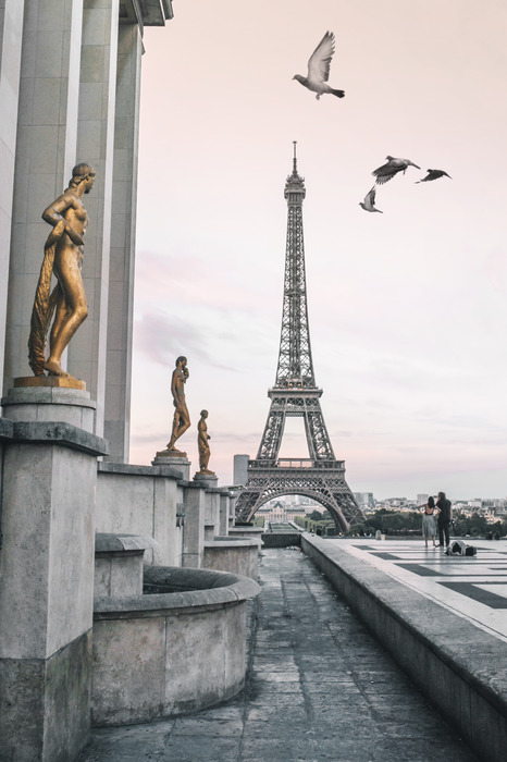 La tour eiffel et les statues sous un ciel rose