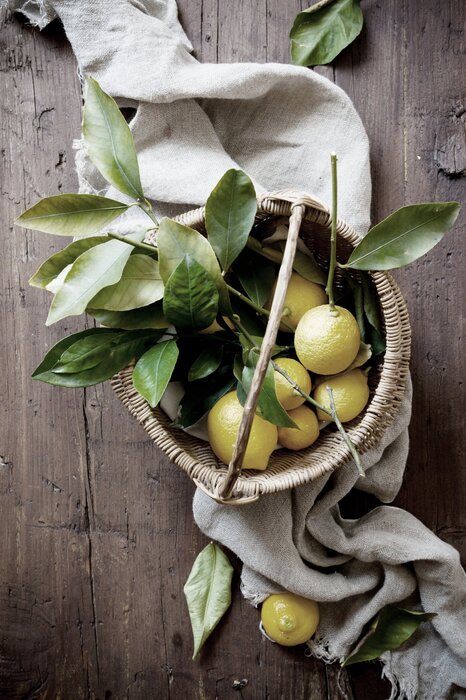 Fruits de citron dans un panier sur une table en bois