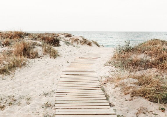 Houten afdaling naar het strand met uitzicht op zee