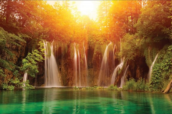 Zonsondergang boven een waterval met turquoise water