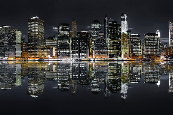 Wolkenkrabbers van new york &#39;s nachts verlicht boven de rivier