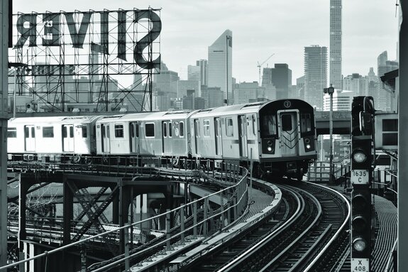 Een monochrome foto van een oude trein op de rails.